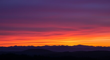 Obraz premium Sunset paints vibrant colors across dramatic sky over mountains. Silhouette landscape.