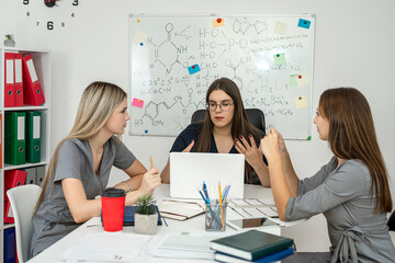 scientists work together in office with blackboard with drawn molecular structures