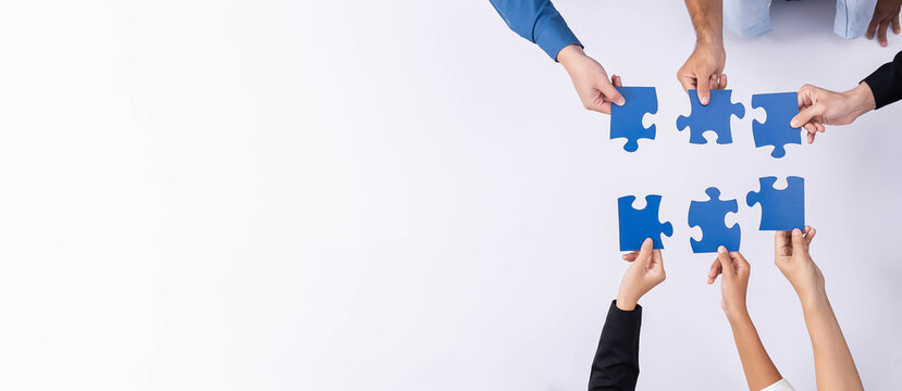 Top view panorama banner of business team joining jigsaw puzzle together over meeting table symbolize business partnership and collective unity teamwork in problem solving solution. Prudent