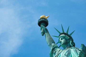 Close up of the Statue of Liberty against a cloudy blue sky, New York City.
