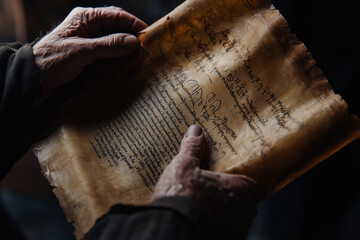 Obraz premium Close-up of hands delicately holding a Torah scroll during a religious ceremony in a quiet, sacred space