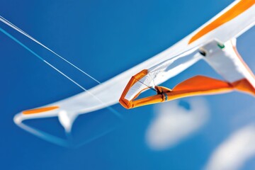 Fototapeta premium A kite soaring through the clear blue sky, its vibrant colors standing out against the cloudless backdrop