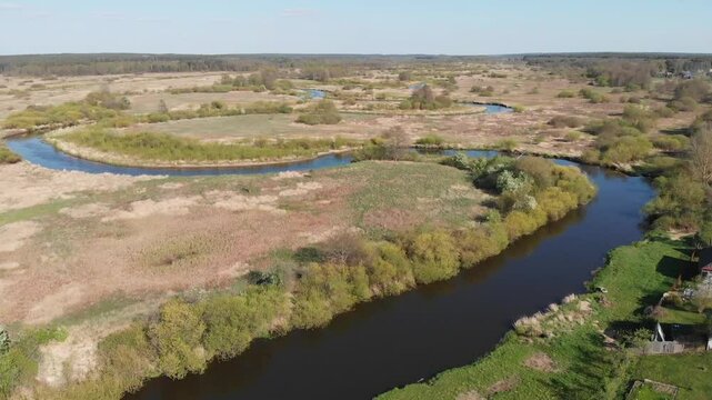 Flying over a river surrounded by a large green field