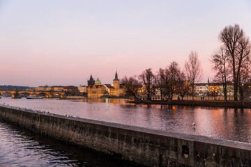 Sunset colors in Prague Historical Gothic Medieval castle, St. Vitus Cathedral, Charles Bridge and river Vltava boat cruise, astronomical clock, Unesco city tourism, golden hour and water reflection