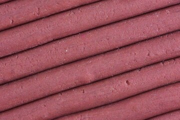 play dough modeling clay rolled into sticks close up top detailed view texture background pink color