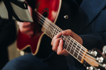 Obraz premium Concert view of an electric guitar player with vocalist and rock band performing in a club, male musician guitarist on stage with audience in a crowded concert club hall arena, hands on a guitar