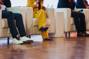 Speakers shoes legs at the business conference event, audience on forum summit, plenary session lecture hall, persons on a stage at plenary meeting, business congress at the venue, panel discussion