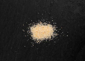 Garlic powder pile, dried granulated chopped crushed garlic cloves, cut into small pieces