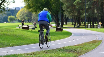 Naklejka premium Old retro road sports bicycle driver bicycling in park sunny summer day.
