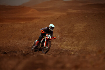 Motocross racer rides through the desert.