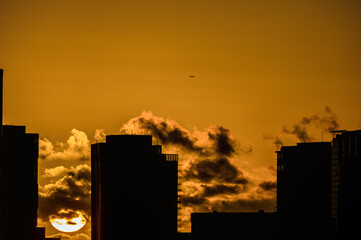 Peaceful Background of a Golden Sunset with an Urban Silhouette in the Foreground.