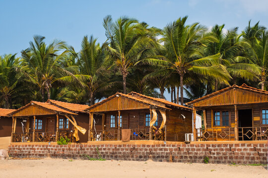 Beachfront wooden cottages with palm trees in the background. Agonda Beach, South GOA, India