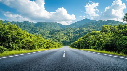 Empty Asphalt Road Through Lush Green Mountains Under a Blue Sky with Fluffy Clouds