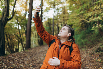No communication coverage, lost contact signal device. Sad blonde man got lost and could not find an internet connection on phone while hiking alone in the forest.