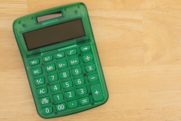 Green calculator on wooden desk