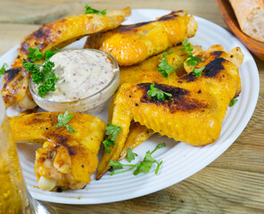 Crispy roasted chicken wings with sauce and parsley