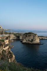 Fototapeta premium The sun sets behind Raouche Rock in Lebanon, casting a stunning glow over the Mediterranean waters. Travel agencies, wallpapers, and social media content.