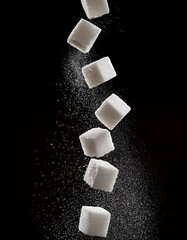 White sugar cubes falling and floating freely on black background