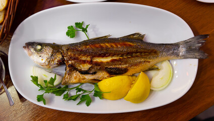 Delicious fish dish, fried bass served with onion, lemon and parsley. Turkish cuisine