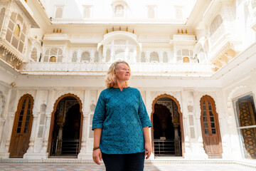 Young blonde woman exploring the architectural beauty of Bikaner city fort in Rajasthan, India