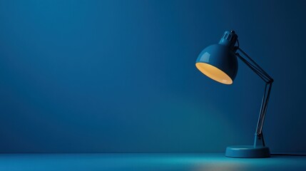 Blue desk lamp illuminates dark room, copy space