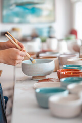 Ein Handwerker arrangiert kunstvolle Keramiken in einem modernen Atelier

