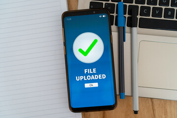 File uploaded successfully notification on smartphone. Concept of upload data to the cloud for...