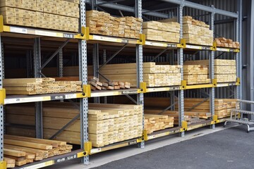 Shelves with wooden boards in a hardware store for construction and repair.