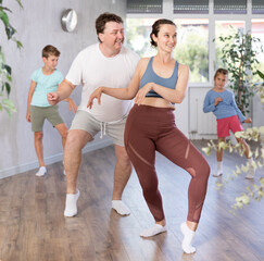 .Cheerful joyful family performs a workout for amateurs. Parents with a young daughter and a...
