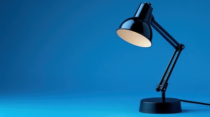 Illuminated desk lamp, blue background, studio shot, workspace