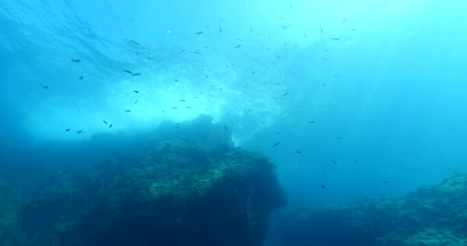 sun rays sun beam sun shine underwater fish around waves on rocks white foam slow backgrounds  ocean scenery