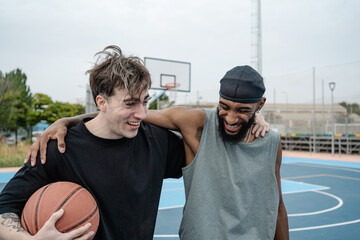 Two basketball players smiling and having fun together after match