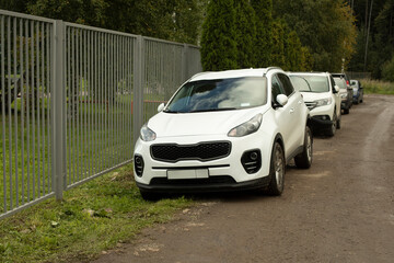 Cars in the parking lot in summer. Parking near the house. Personal transport in the city.
