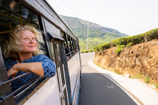 Female tourist having a bus ride from Munnar to Marayoor along tea plantations in Kerala, India