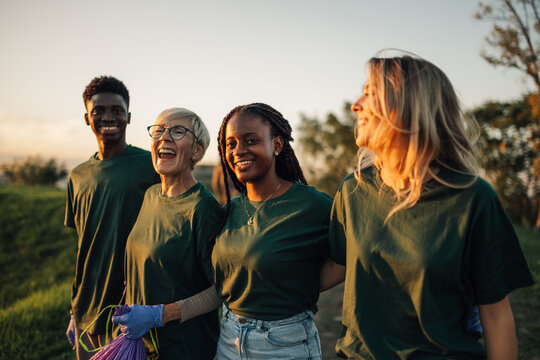 Group of volunteers walking together and smiling after cleaning the park