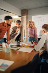 Marketing team analyzing charts and developing new strategy during brainstorming meeting