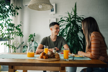 Lesbian couple enjoying breakfast and talking at home