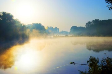 A foggy morning with a lake in the background