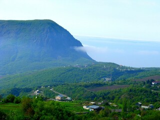 A mountain range with a foggy sky and a town in the distance