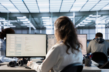 Technician in server hub ensuring valuable data remains shielded from potential threats using PC....