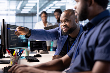 Admin requesting help from team leader reconfiguring server farm to optimize it for data processing requirements. IT expert showing intern how to ensure data center equipment operates efficiently