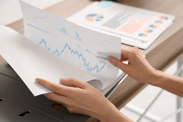 Young businesswoman with document folder in office. Closeup