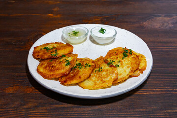 Popular savory pancakes served with creamy sauces on a rustic table Savory vegetable pie served with fresh garnishes on a white plate