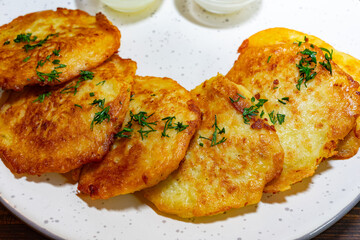 Delicious potato pancakes served with dipping sauce at a local eatery Savory vegetable pie served with fresh garnishes on a white plate