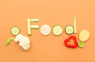 Word FOOD made of fresh vegetables on color background