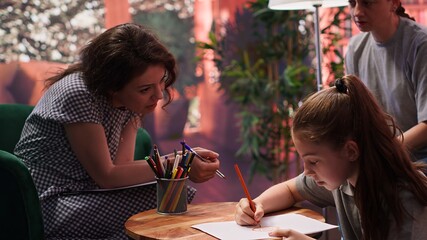 Therapist guiding a troubled teen through creative therapy system, using drawing as a method to...