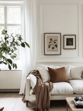 Design sofa, tropical plant, pillows, blanket, gramophone, and mock up picture frames are all featured in this stylish Scandinavian white room. Modern living area with white walls and brown oak parqu