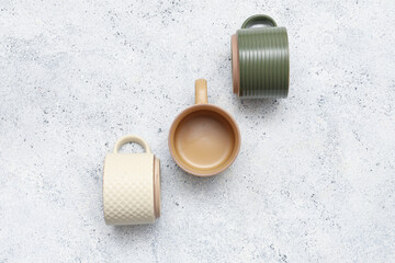 Different ceramic mugs on white grunge background