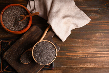 Bowls and spoon with chia seeds on wooden background