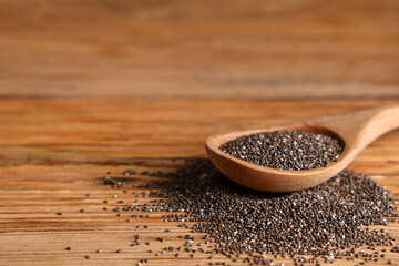 Spoon with chia seeds on wooden background